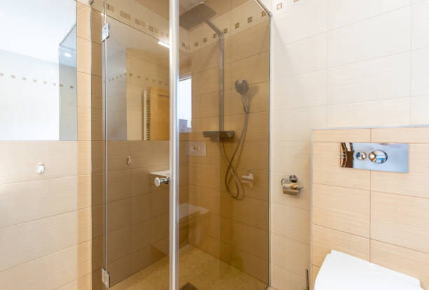 istock Modern Bright Bathroom Interior Featuring Glass Shower and Neutral Tile Design 2203463655