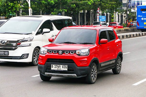 Jakarta, Indonesia - February 16, 2025: Red compact city car Maruti Suzuki S-Presso in the city street.