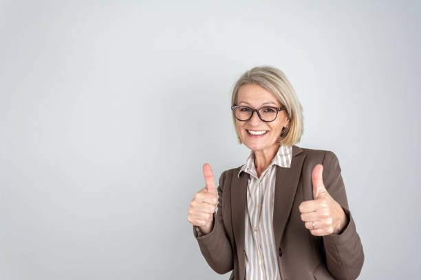 istock Businesswoman pointing fingers up at empty copy space 2203468531