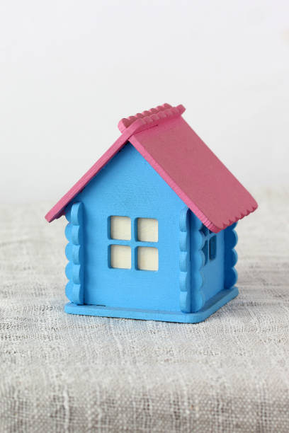 Small blue and pink wooden toy house representing the concept of home, family, real estate and childhood memories