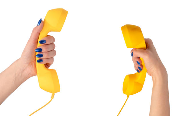 Yellow handset in woman hand isolated on white. Copy space.