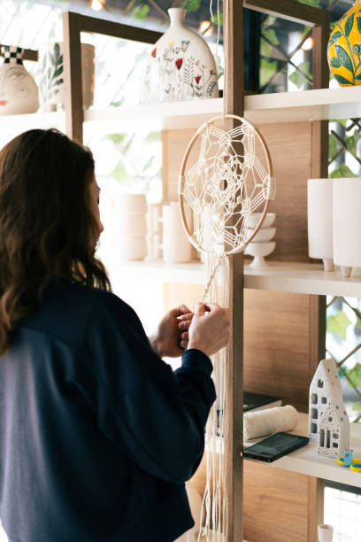 istock Woman making macrame dream catcher in a craft store 2203471810