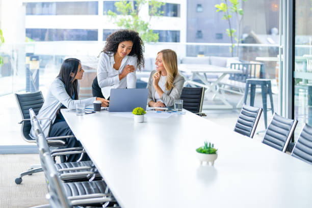 istock Three business  women meeting. They are discussing something while looking at a laptop computer. 2203480171