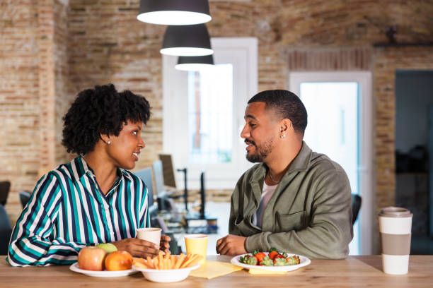 istock Colleagues enjoying break time with healthy snacks and conversation in modern office 2203482567