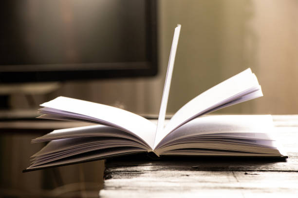 An open book on a table at home in the light, read