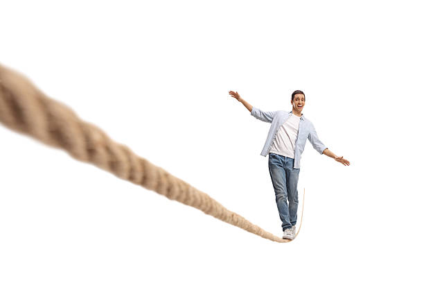istock Young man trying to walk on a tighrope 2203492203
