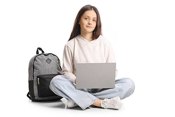 istock Teenage female student sitting with crossed legs and using a laptop computer 2203492841
