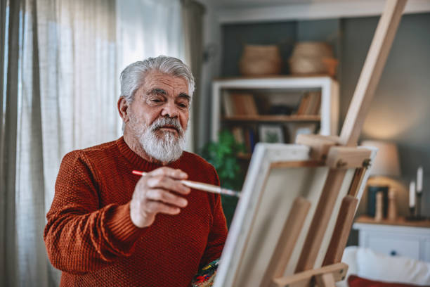 istock Senior artist painting on canvas at his home studio 2203495606