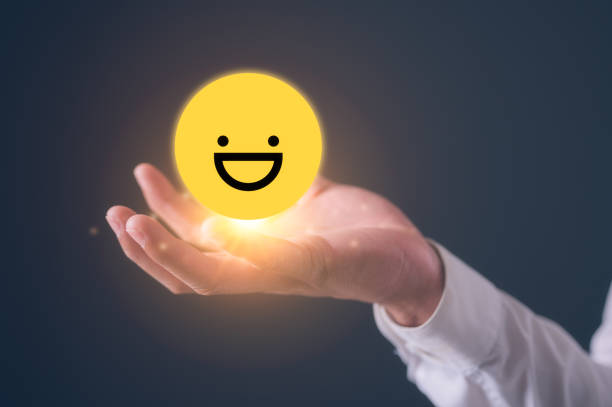 istock Customer service experience and satisfaction survey concept, man hand holding a smiling happy emotional icon. Review, Service rating, satisfaction 2203496080