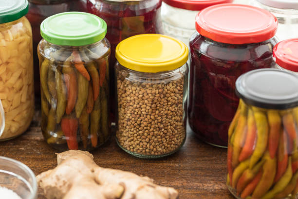 Fermenting food process, corriander seed in glass jar with fermented chillies, ginger and beet root