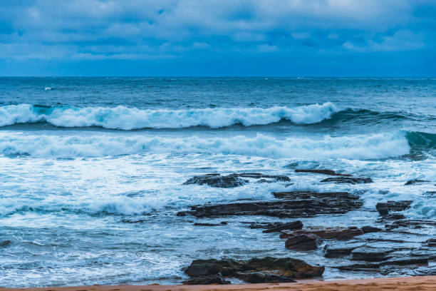 Overcast Sunrise Seascape with rocks and waves at Avalon on the Northern Beaches of Sydney, NSW, Australia.