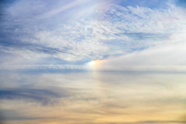Optical effect of colored lights between the clouds of a blue sky