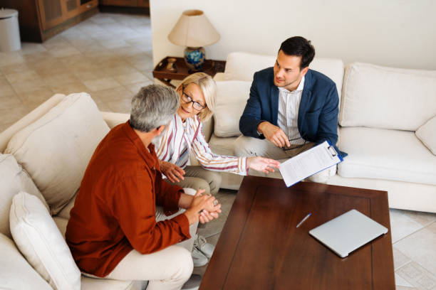 istock Casually clothed couple talking with financial advisor at their apartment 2203503410