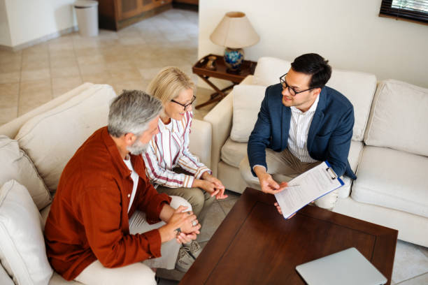 istock Casually clothed couple talking with financial advisor at their apartment 2203503430