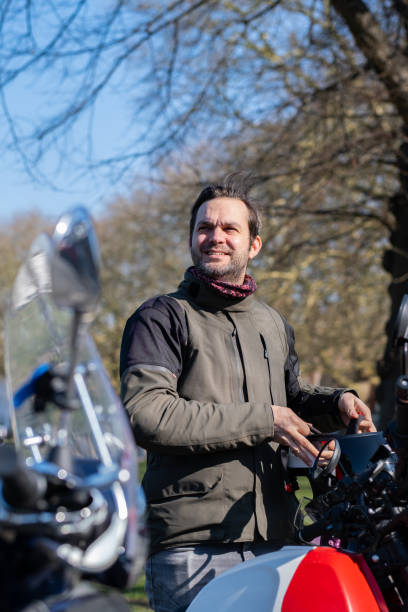 istock Male rider putting on motorcycle helmet 2203506414