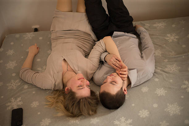 istock Couple Reclining on Bed Sharing Affection with Cozy Background 2203507480