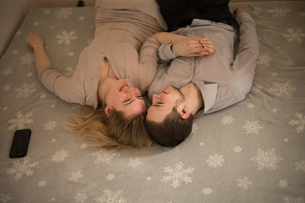Couple Relaxing Together on Bed with Winter-Themed Background