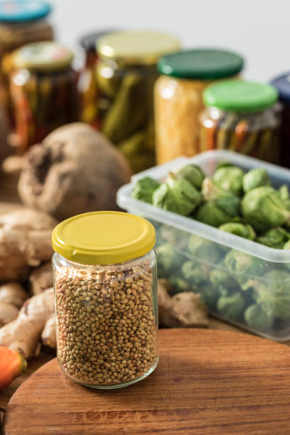 istock Coriander seed in glass jar with vegetables in background on table 2203509223