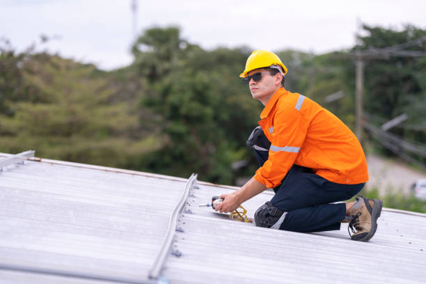 istock Focused worker in an orange safety uniform helmet kneeling on a rooftop holding tools. A scene showcasing attention to detail, safety, and commitment to electrical or structural installation tasks. 2203509238