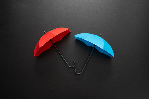 Opened red and blue umbrellas isolated on blank black background