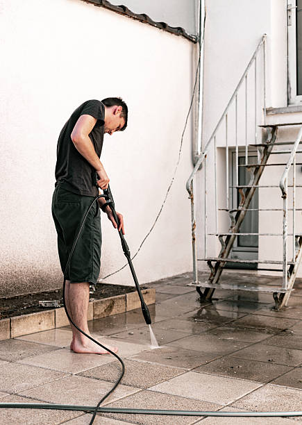 istock A guy washes garden tiles with a pressure washer in a courtyard. 2203510305