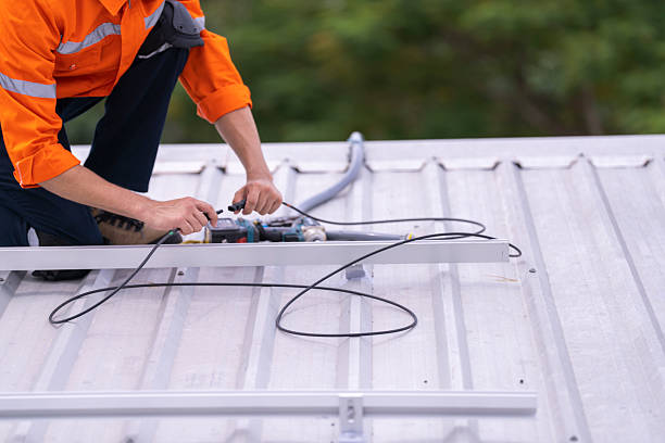 istock Technician in an orange safety uniform and helmet handling an electrical cable on a rooftop. Represents safety, professionalism, and expertise in renewable energy installations and maintenance work. 2203510329