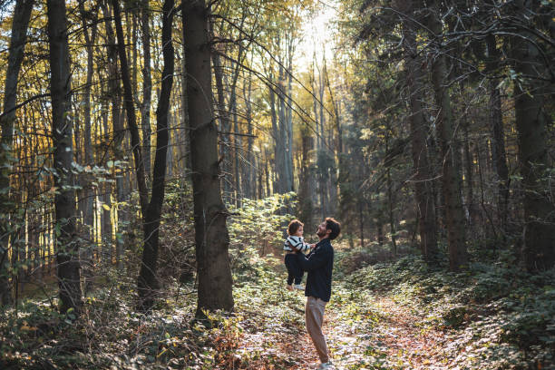 istock Father and child enjoying a sunny walk in the forest 2203510668