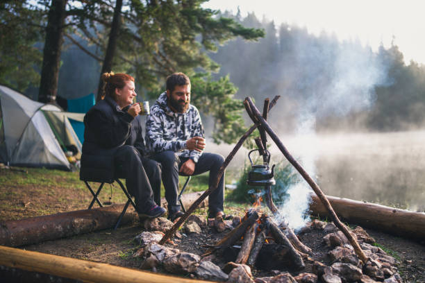 istock Couple enjoying hot tea on a serene camping morning. 2203510937