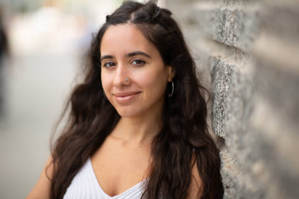 istock Close up cute young woman leaning against wall 2203511054