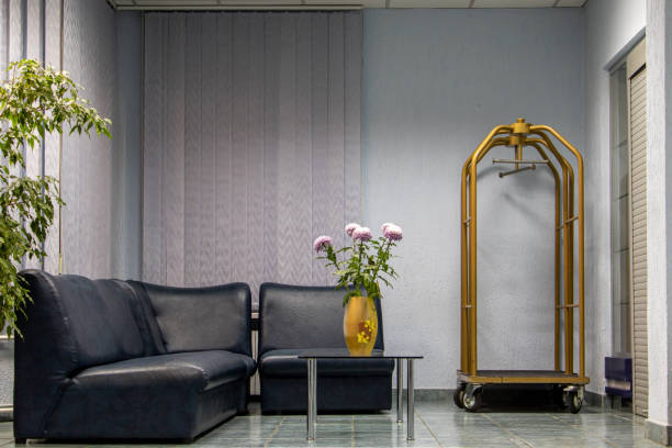 A hotel interior with seating area and luggage trolley.