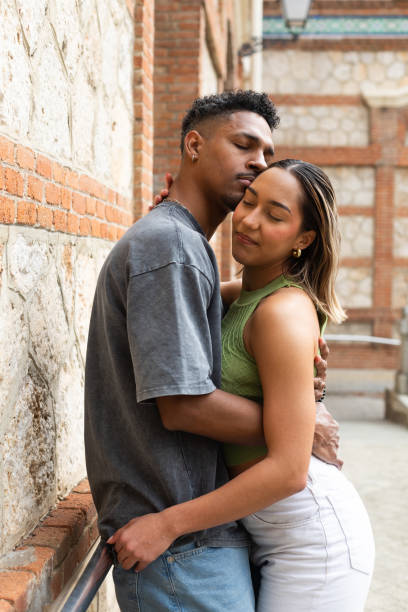 istock Young couple embracing tenderly in urban setting 2203521439