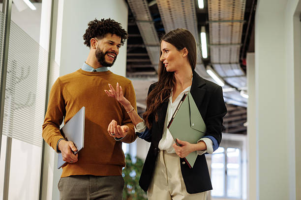 istock Colleagues walking, smiling and talking in the office 2203522146