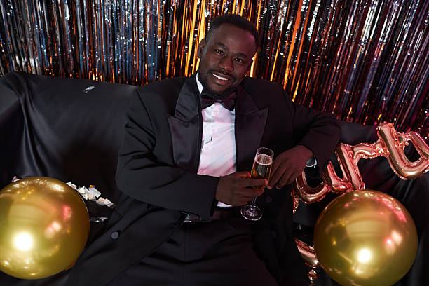 istock Smiling Man Holding Drink at Celebratory Event 2203533166