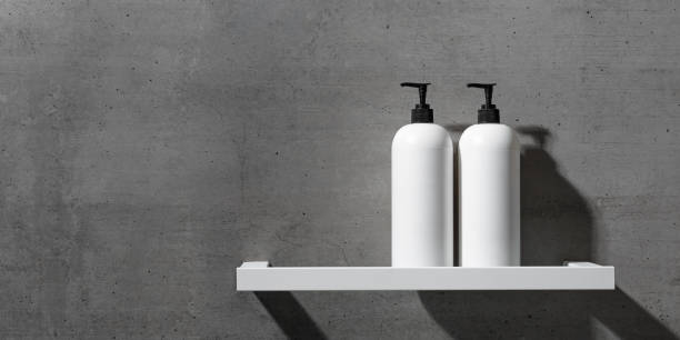 istock White bottles mock up on white shelf on gray concrete background, close up shampoo, conditioner. Aesthetic view beauty products in modern minimal bathroom neutral color. Side view, banner 2203535196