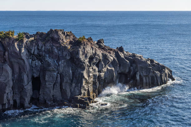 istock Gray rocks, blue sea and white waves 2203537703