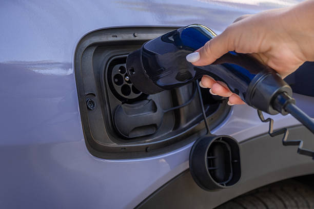 istock A woman's hand charges a purple EV electric car 2203537737