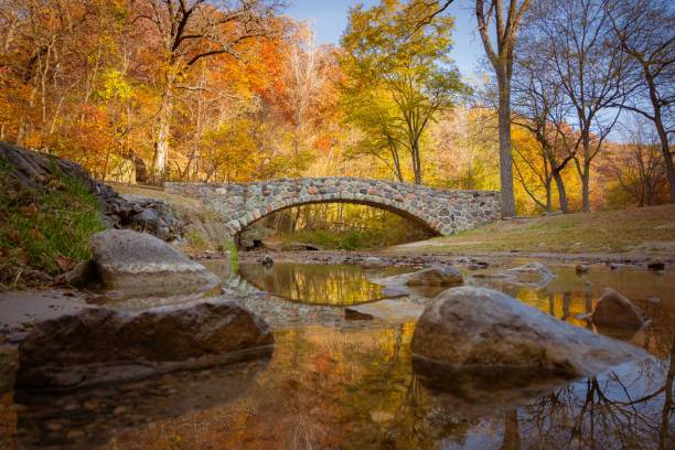 Pedestrian rock bridge over Peas Creek in Ledges State Park, Iowa, during fall