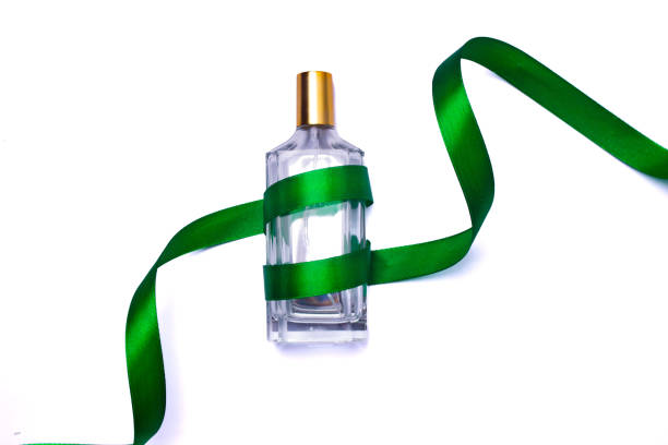 Glass perfume bottle with orange liquid and silver cap, isolated on white background. Elegant fragrance container for cosmetics, beauty, or scent-related design and advertising use.