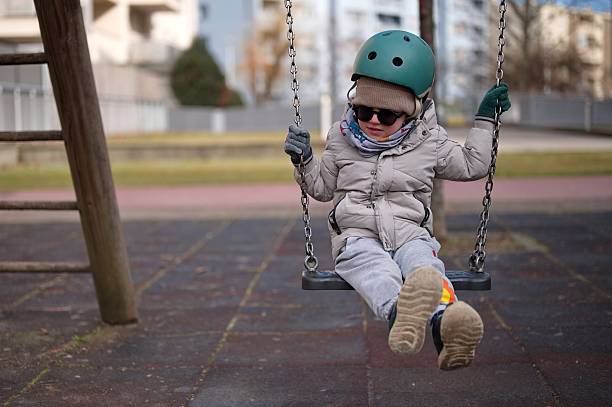 Little boy swinging on the playground