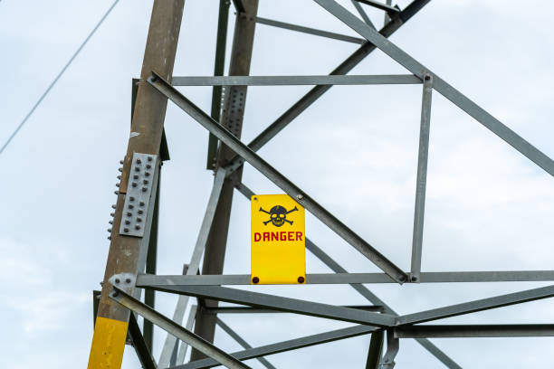 High Voltage danger sign at high voltage transmission tower.