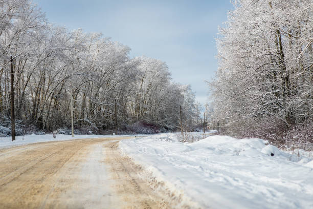 istock Winter landscape - road and trees in snow on a sunny day 2203544879