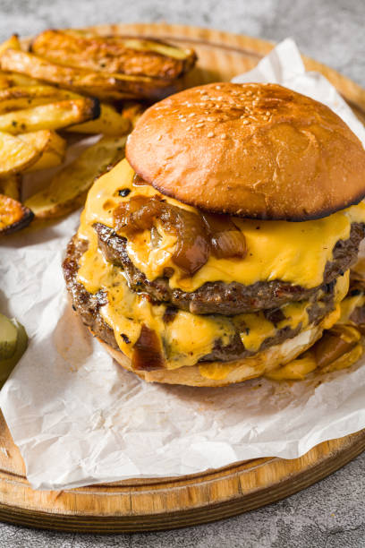 istock Smash burger with cheddar cheese and caramelized onions, served with fries 2203548217