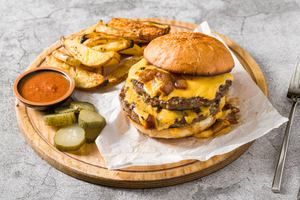 istock Smash burger with cheddar cheese and caramelized onions, served with fries 2203548218