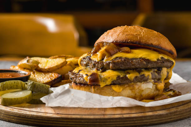 istock Smash burger with cheddar cheese and caramelized onions, served with fries 2203548223