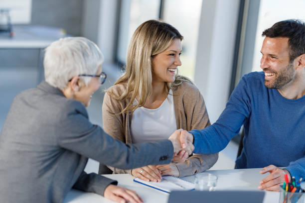 istock Happy insurance agent congratulating her customers on successful meeting in the office. 2203550131