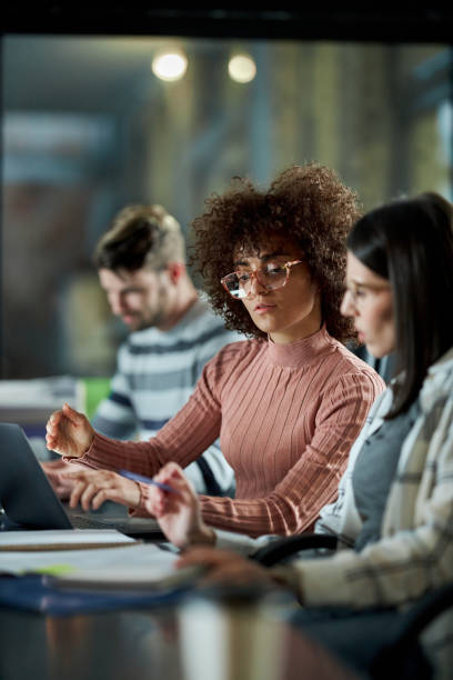 istock Young female programmers working on laptop late in the office. 2203550974