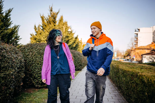 istock Two young adults on a date walking outdoors in public park on sunny day 2203553612