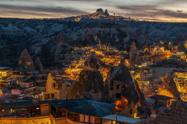 istock Cappadocia's unique rock formations and illuminated town at dusk 2203555016
