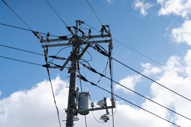 istock Electric pole with connected wires against a blue sky. 2203556416