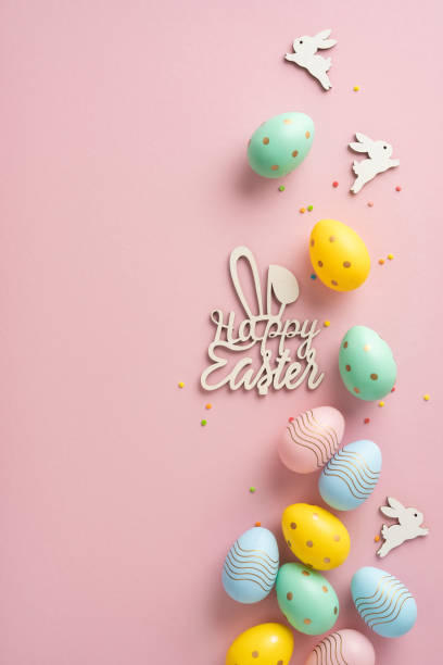 istock Colorful vertical Easter eggs and festive decorations arranged creatively on a pink background to convey a cheerful holiday feeling 2203556792